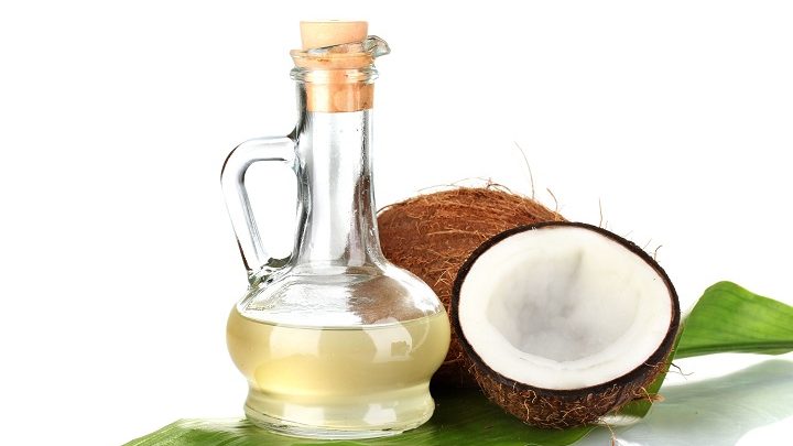 15455977 - decanter with coconut oil and coconuts isolated on white